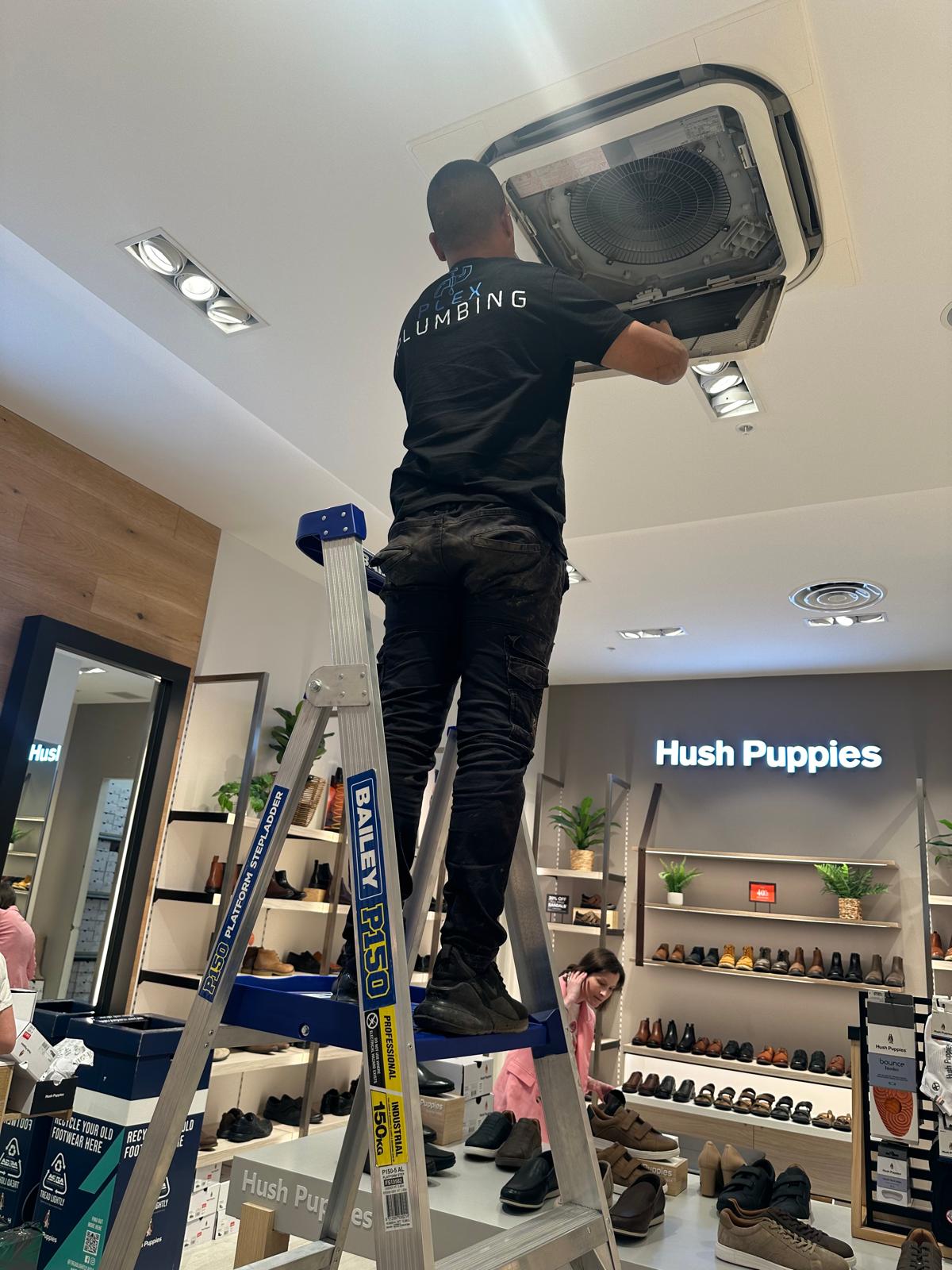 Employee Installing Airconditioner Retail - Plex Plumbing Melbourne